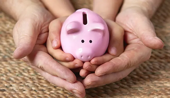 kids hands holding piggy bank